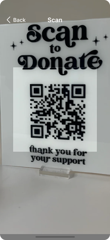 Image of a sign with a QR code that reads ‘Scan to Donate’ at the top and ‘thank you for your support’ at the bottom. The QR code is prominently displayed in the center, inviting users to scan and make a donation.